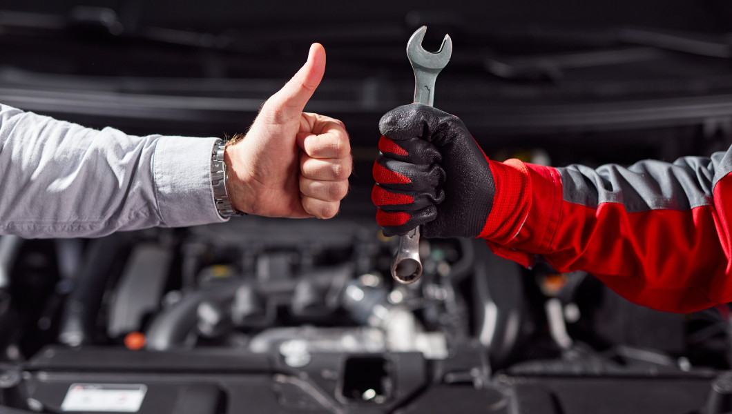 crop-unrecognizable-businessman-showing-thumb-up-gesture-while-standing-with-auto-mechanic-with-wrench-hand-near-broken-car-garage 1